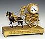 An extremely rare ormolu French empire mantel clock, depicting the Wine Harvest by a Bacchante driven and horse drawn char.